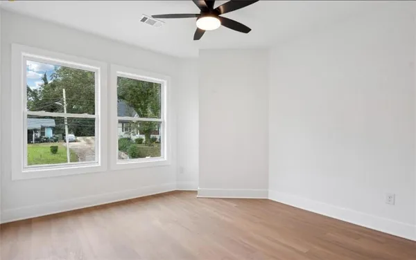 an empty room with window and a ceiling fan
