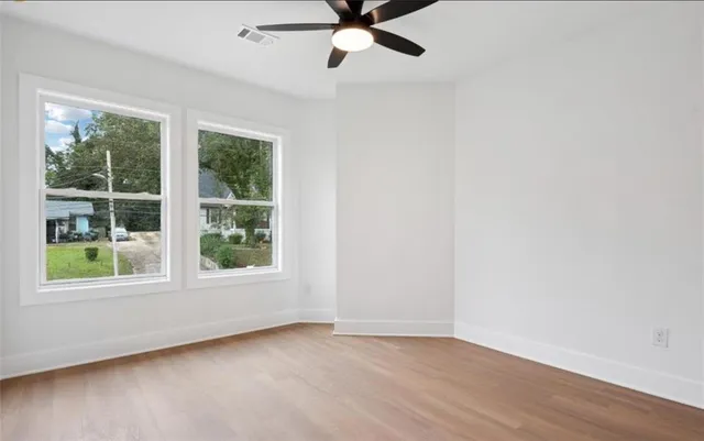 an empty room with window and a ceiling fan