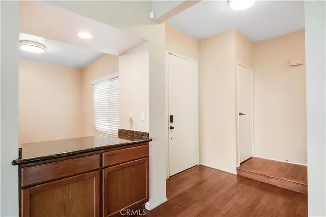 a kitchen with granite countertop a sink cabinets and a wooden floor