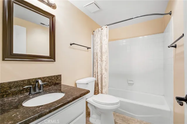 a bathroom with a granite countertop sink toilet mirror and shower
