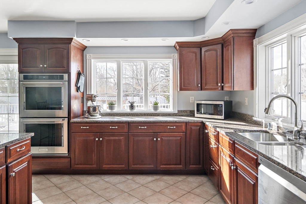 191 Centre Street Danvers, MA 01923 - Photo 12 of 40 a kitchen with stainless steel appliances granite countertop a stove a sink and a microwave