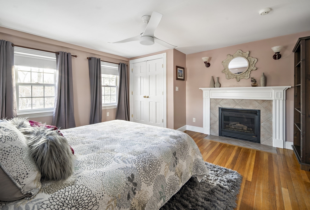 191 Centre Street Danvers, MA 01923 - Photo 17 of 40 a spacious bedroom with a bed and a fireplace