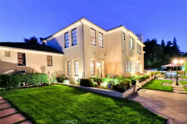 a view of a swimming pool with lawn chairs under an umbrella