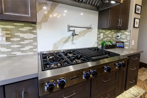 a kitchen with granite countertop white cabinets and black appliances