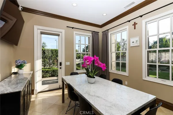 a dining room with furniture potted plants and wooden floor