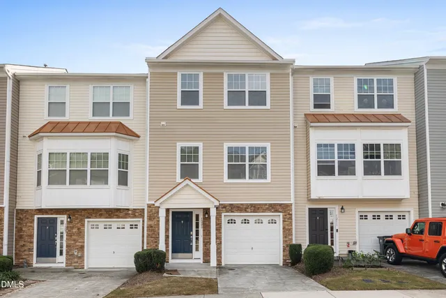 a front view of a residential apartment building with a yard