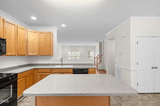 a kitchen with granite countertop a refrigerator stove top oven and sink