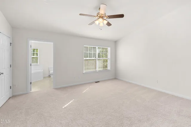 an empty room with chandelier fan