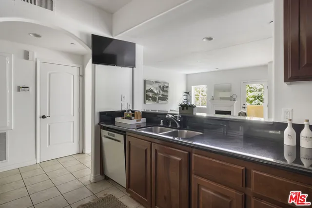 a kitchen with stainless steel appliances granite countertop a sink and a refrigerator