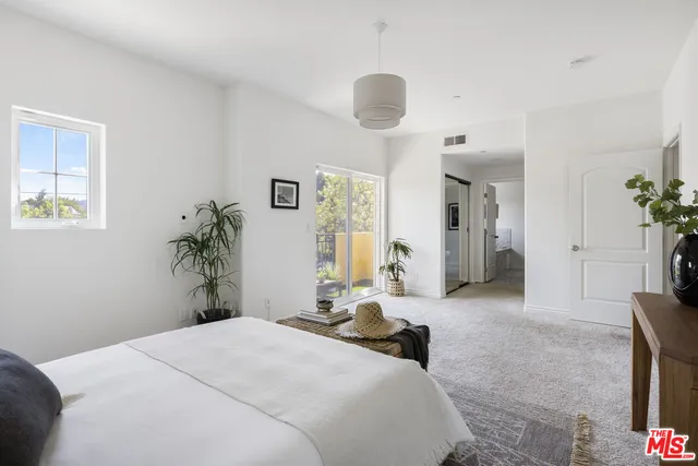 a bedroom with a bed and a potted plant