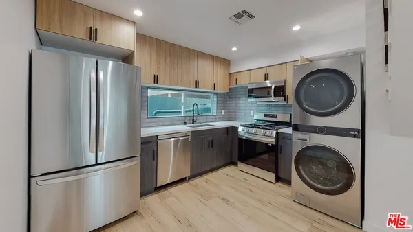 a kitchen with a refrigerator sink and cabinets