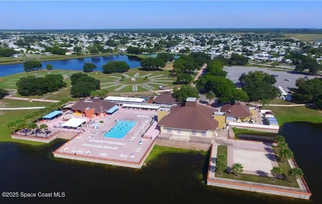 an aerial view of a house with a garden and lake view