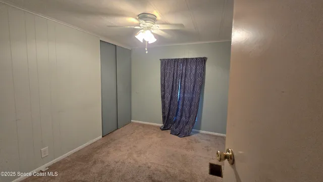 an empty room with a ceiling fan and a window
