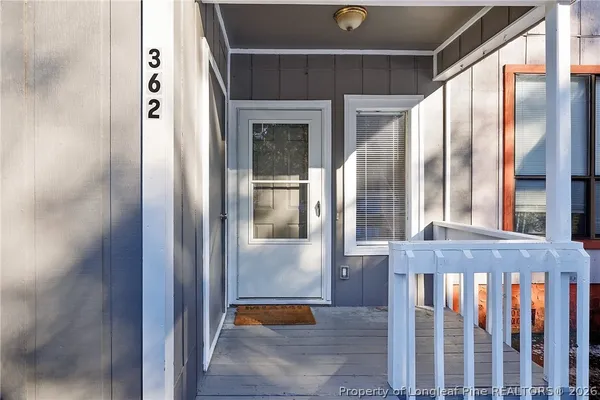 a view of a hallway with wooden floor and entryway