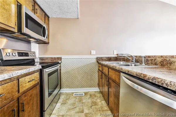 a kitchen with kitchen island a counter top space appliances and a refrigerator