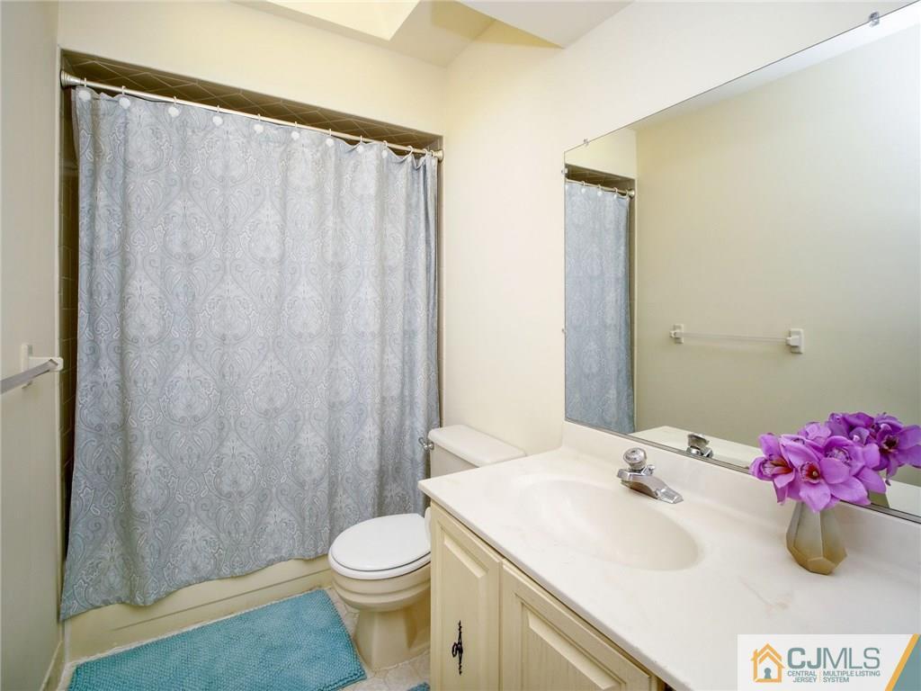 1402 Timber Oaks Road, Unit 1402 Edison, NJ 08820 - Photo 13 of 19 a bathroom with a sink a toilet and shower curtain