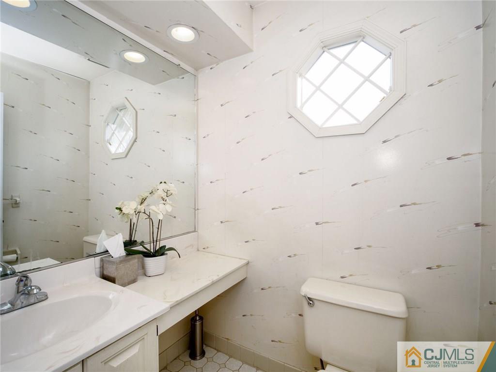 1402 Timber Oaks Road, Unit 1402 Edison, NJ 08820 - Photo 15 of 19 a bathroom with a sink a toilet and a mirror
