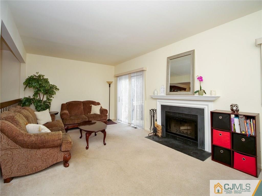 1402 Timber Oaks Road, Unit 1402 Edison, NJ 08820 - Photo 4 of 19 a living room with furniture and a fireplace