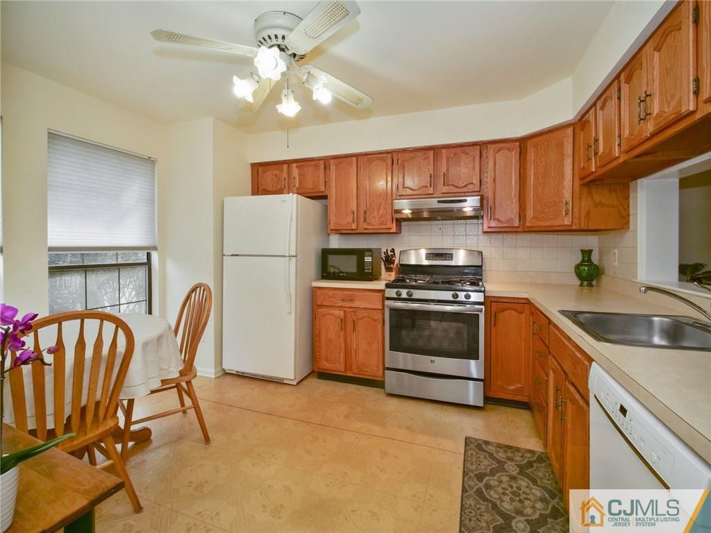 1402 Timber Oaks Road, Unit 1402 Edison, NJ 08820 - Photo 6 of 19 a kitchen with a stove a sink and a refrigerator