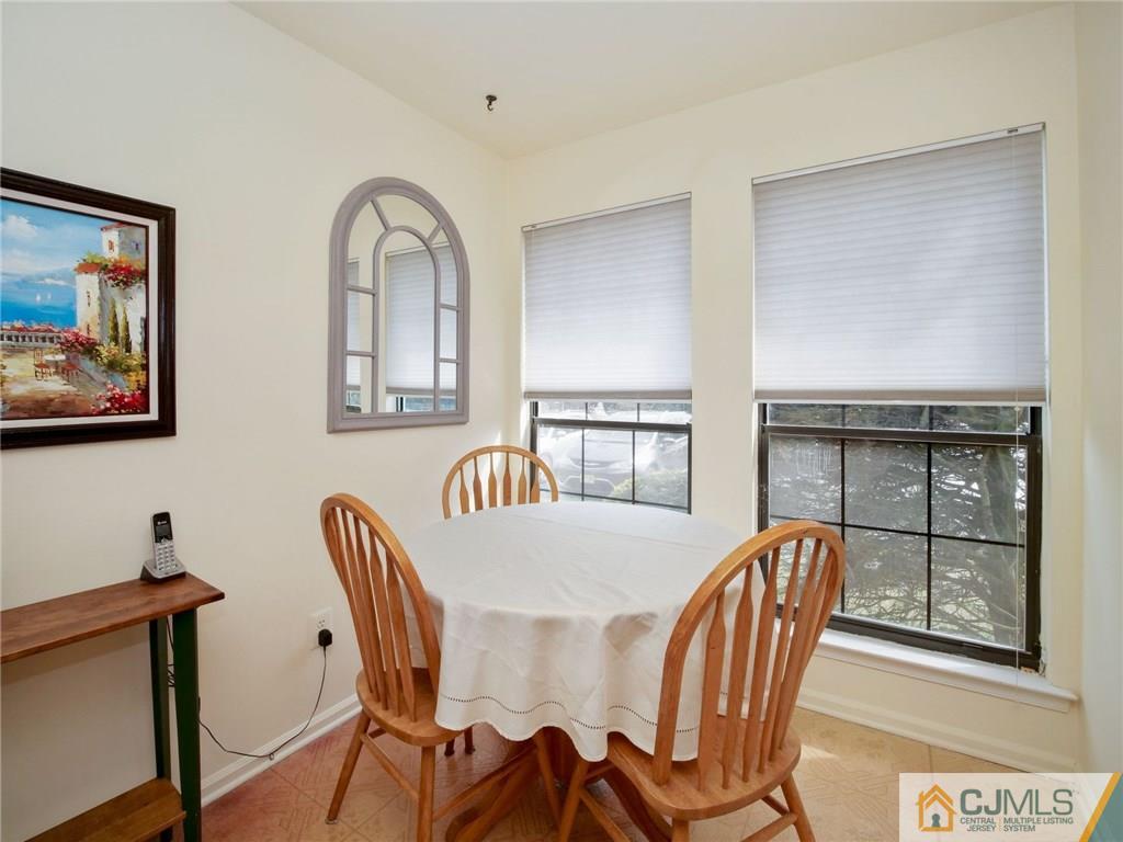 1402 Timber Oaks Road, Unit 1402 Edison, NJ 08820 - Photo 7 of 19 a view of a dining room with furniture and a window