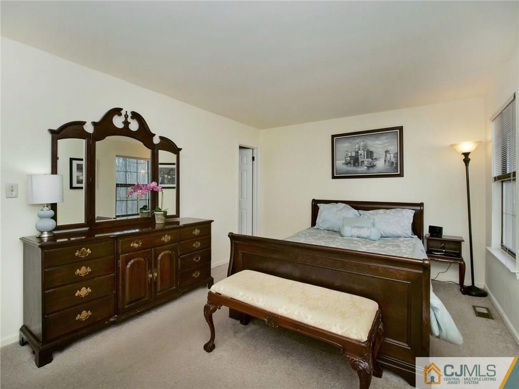 1402 Timber Oaks Road, Unit 1402 Edison, NJ 08820 - Photo 9 of 19 a bedroom with a bed and a dresser