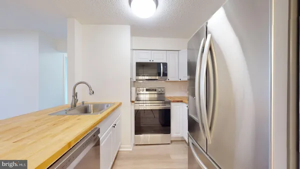 a kitchen with stainless steel appliances granite countertop a refrigerator and a stove top oven