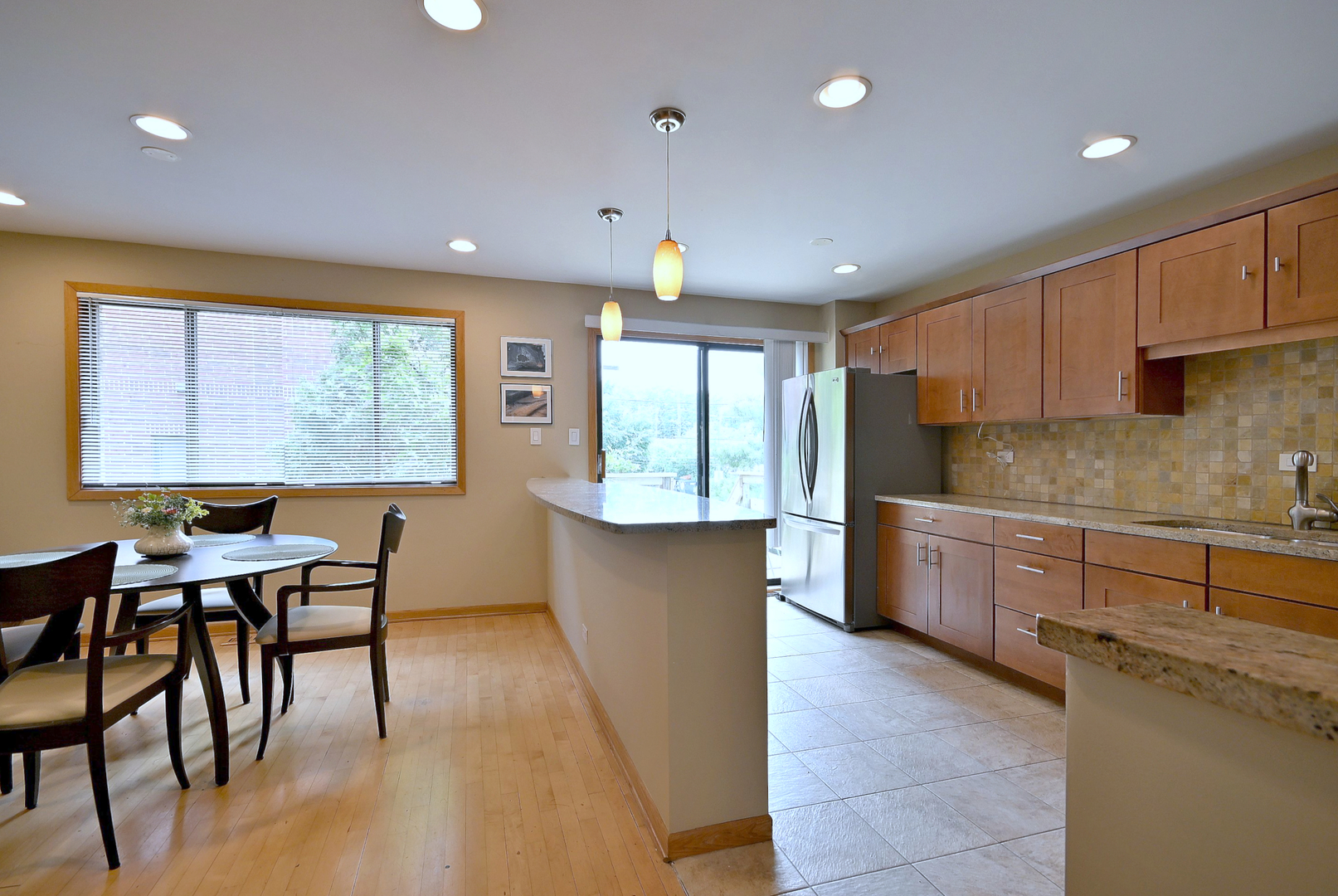 2350 North Sayre Avenue, Unit G Chicago, IL 60707 - Photo 8 of 30 a kitchen with stainless steel appliances granite countertop wooden cabinets a dining table and chairs next to a window