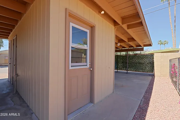 a view of a house with a potted plant ana a small yard