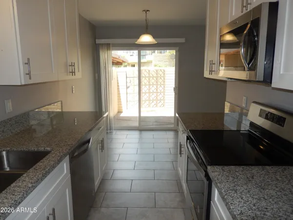 a bathroom with a granite countertop toilet sink and mirror