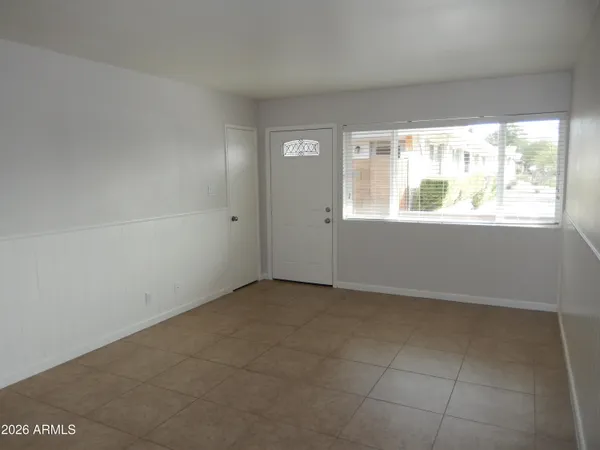an empty room with a window and a fan