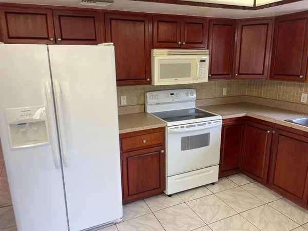 en empty room with windows and chandelier