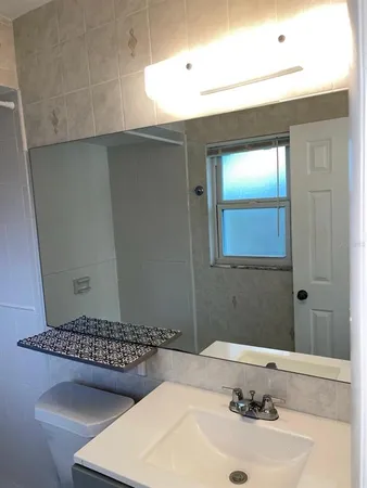 a bathroom with a granite countertop bathtub shower sink vanity and toilet