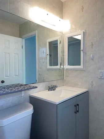 a bathroom with a granite countertop sink and a mirror