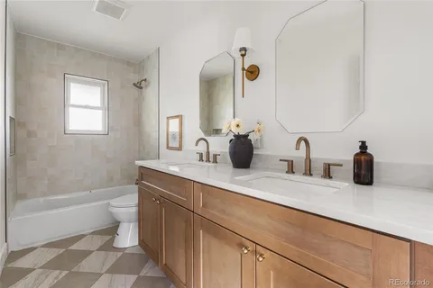 a bathroom with a double vanity sink toilet and shower