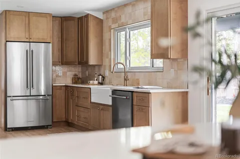 a kitchen with a refrigerator sink and cabinets