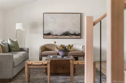 a living room with furniture and a painting on the wall
