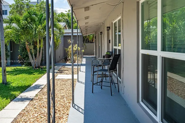 a view of a patio with table and chairs and floor to ceiling window