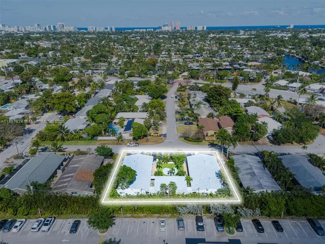 an aerial view of residential houses with outdoor space and parking