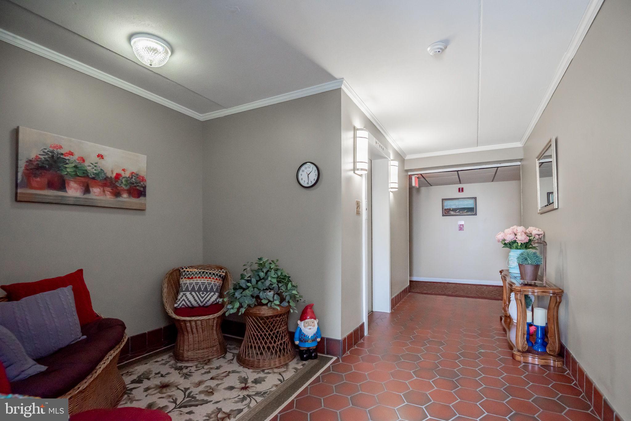 68 Welsh Tract Road, Unit 202 Newark, DE 19713 - Photo 6 of 6 a living room with furniture stairs and a potted plant
