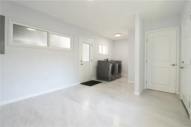 a view of an empty room with closet and a window