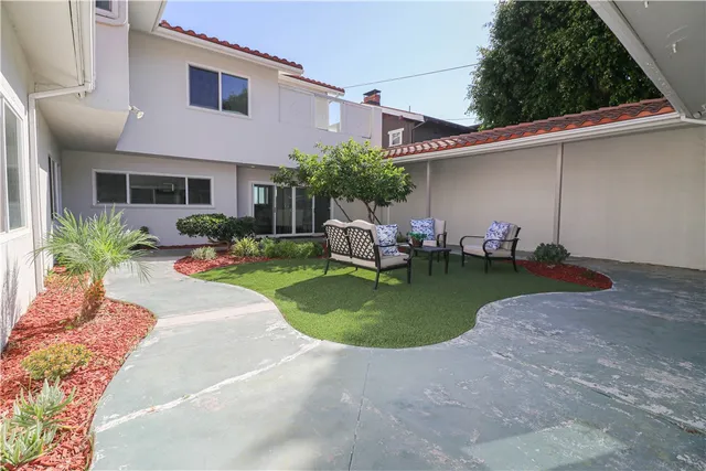 a view of a house with backyard sitting area and garden