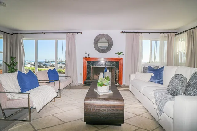 a living room with furniture a large window and a fireplace