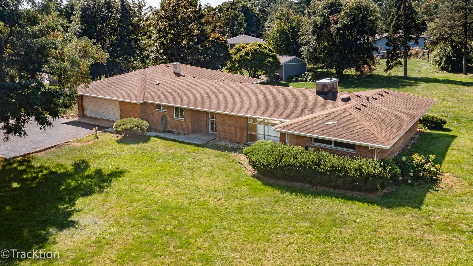 an aerial view of a house with yard and swimming pool