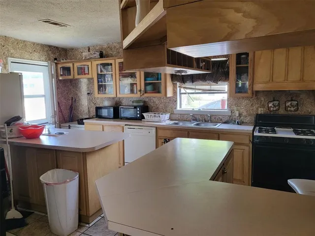 a kitchen with a sink refrigerator and cabinets