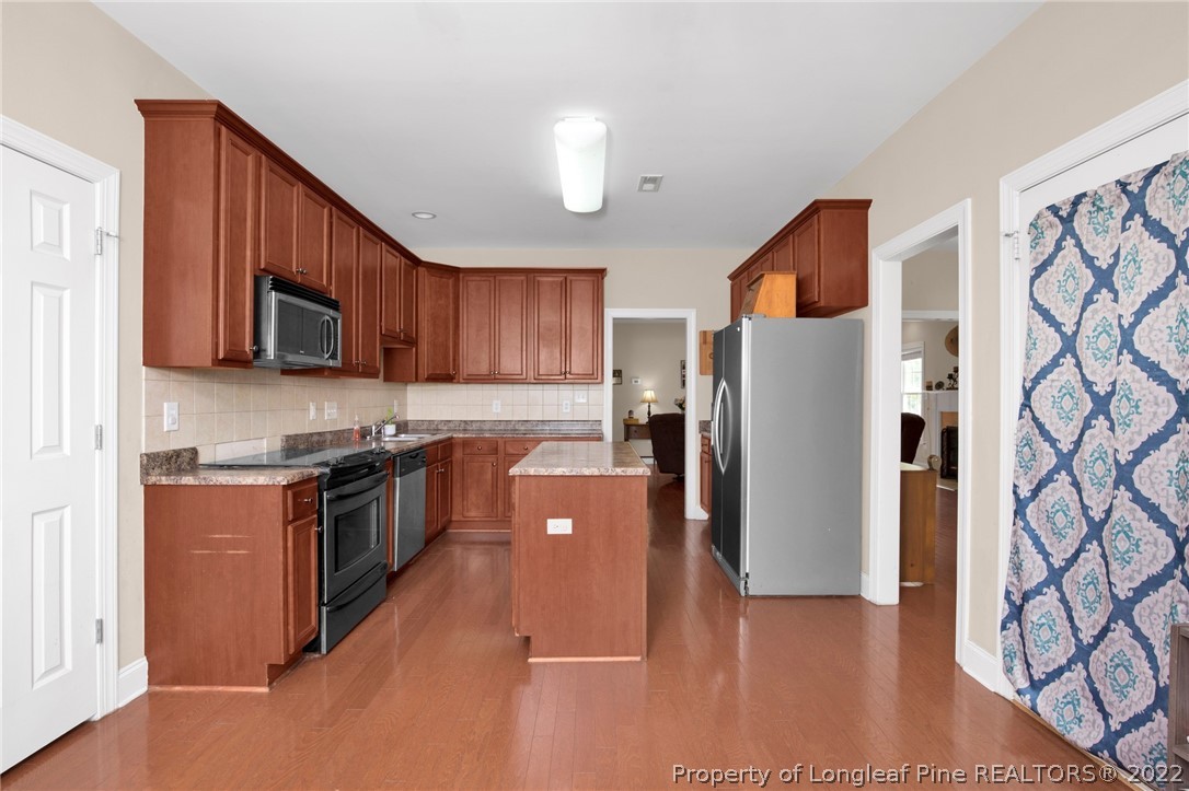 515 Booth Pond Road Raeford, NC 28376 - Photo 13 of 39 a kitchen with stainless steel appliances granite countertop a refrigerator stove top oven a sink and dishwasher with wooden floor