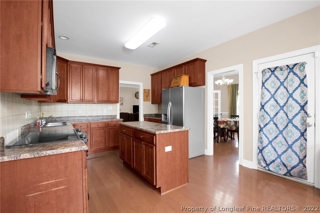 515 Booth Pond Road Raeford, NC 28376 - Photo 16 of 39 a kitchen with stainless steel appliances granite countertop a stove top oven a refrigerator a sink and dishwasher with wooden floor
