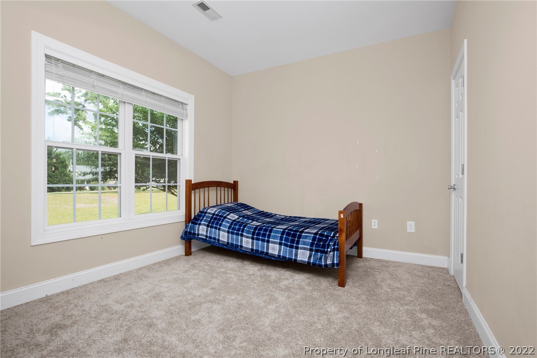 515 Booth Pond Road Raeford, NC 28376 - Photo 22 of 39 a living room with a bed and a window