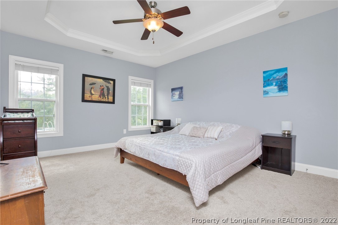 515 Booth Pond Road Raeford, NC 28376 - Photo 29 of 39 a bedroom with a bed and a chandelier