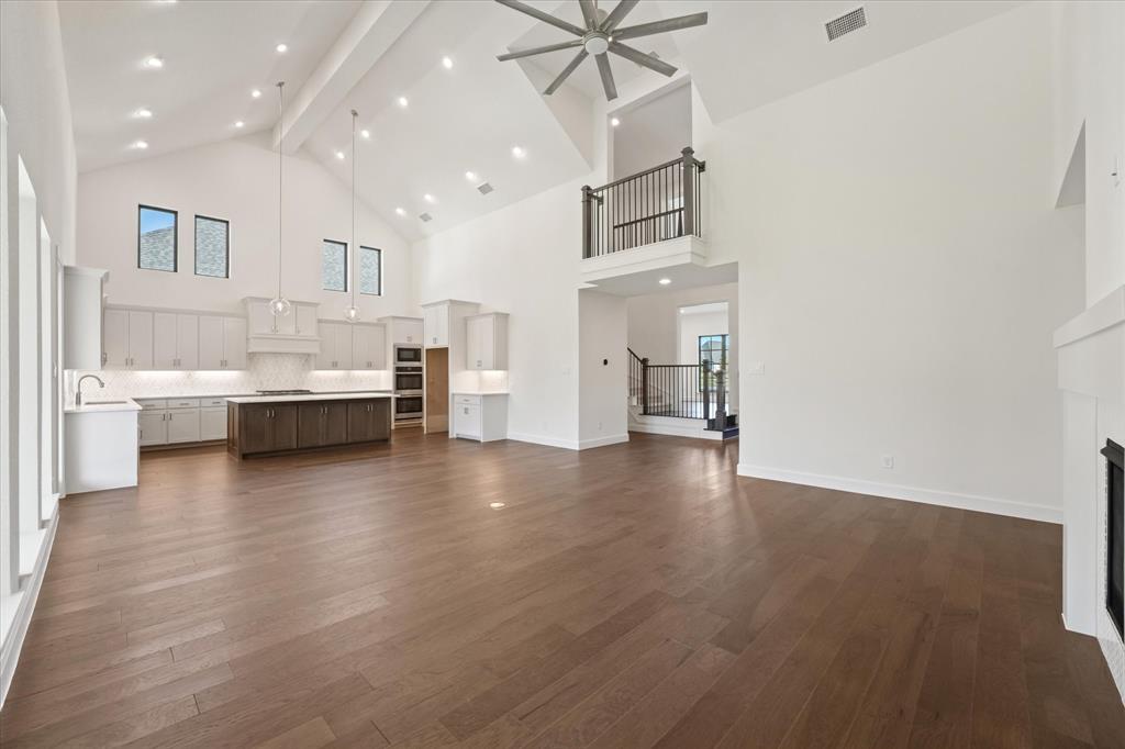 4626 Rillstone Road Midlothian, TX 76065 - Photo 8 of 40 Unfurnished living room featuring beamed ceiling, a fireplace, dark wood-style flooring, high vaulted ceiling, and recessed lighting