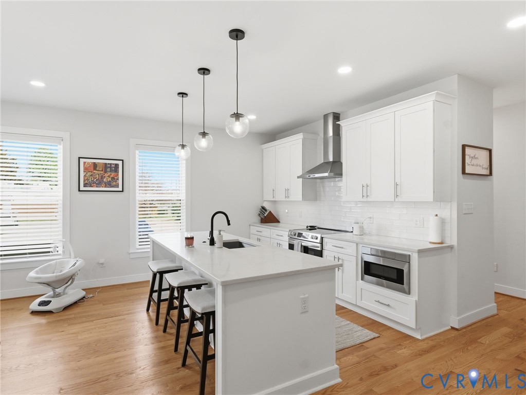 1202 North 34th Street Richmond, VA 23223 - Photo 7 of 36 Kitchen with white cabinetry, a breakfast bar, sta
